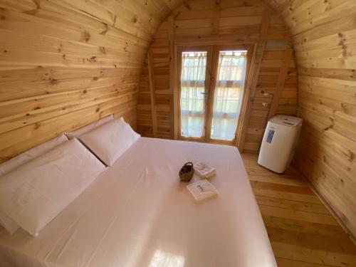 Cette chambre en bois comprend un grand lit blanc. dans l'établissement Tenuta Morganti, à Torano Nuovo