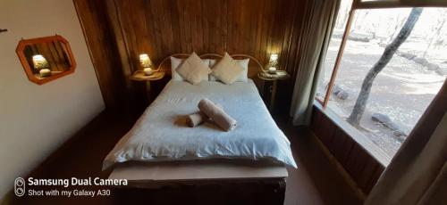 a bedroom with a bed with a cross on it at ThabaNkwe Bushveld Inn in Thabazimbi