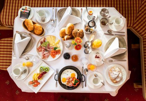 a white table with plates of food on it at Hotel Tannbergerhof im Zentrum von Lech in Lech am Arlberg