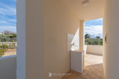 a white kitchen with a view of the ocean at Cava Li Santi Residence in Nardò