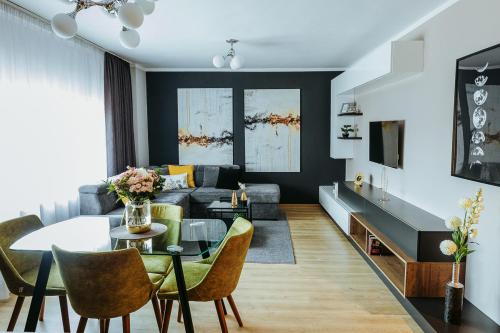 een woonkamer met een bank en een tafel bij Charlotte Apartment - 2Bedrooms w Parking near Nymphaea in Oradea