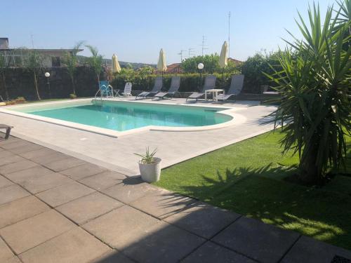 - une piscine dans une cour entourée de chaises dans l'établissement Royal Etna Stars, à Zafferana Etnea