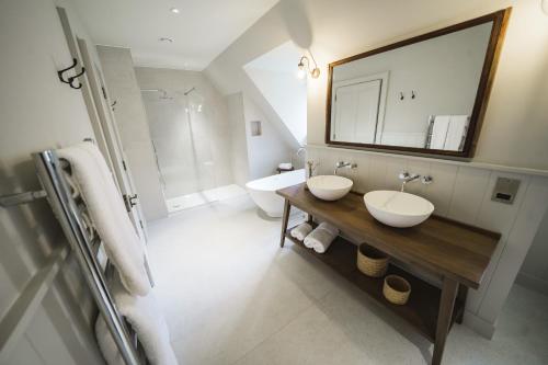 a bathroom with two sinks and a tub at Highfield Park in Hook