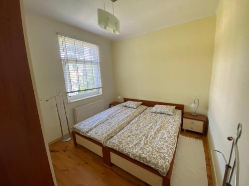 a bedroom with a bed and a window at Family Apartments in Jūrmala