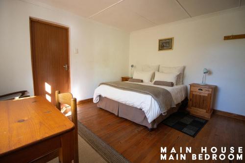 a bedroom with a bed and a wooden floor at JAYA'S PLACE in Hogsback