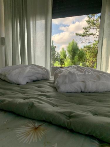 a bed with two pillows in front of a window at PicoTerrace in Madalena
