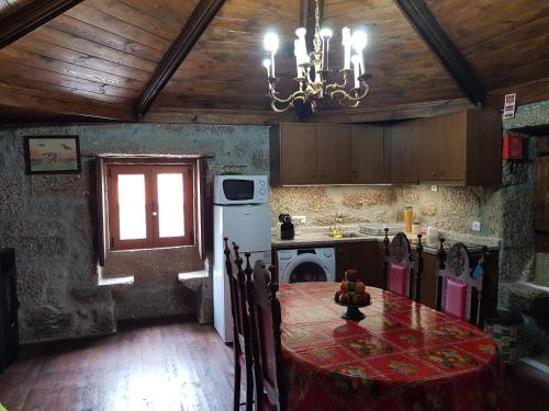 a kitchen with a dining room table and a chandelier at Casa da Relva Experiência Temática Inspirada em Harry Potter in Lamego