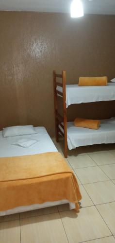 a room with two beds and a wall at Hospedaria Ipiranga in São Paulo