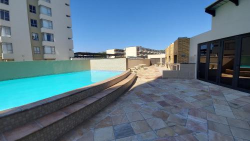 a swimming pool on the roof of a building at Ocean View Luxury Self-Catering in Strand