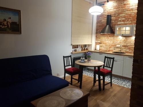 - un salon avec un canapé et une table avec des chaises dans l'établissement H&T Apartament Przy Starym Ratuszu, à Gdańsk