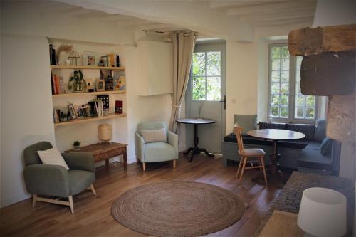 a living room with chairs and a table at Le Clos des Noues in Hermeray