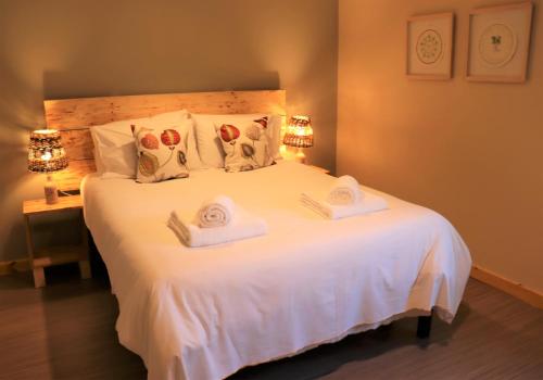 a bedroom with a large white bed with towels on it at South Downs Eco Lodge & Camping in East Meon
