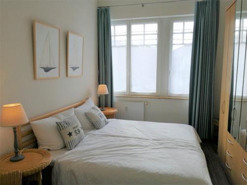 キュールングスボルンにあるAppartmenthaus Miramareのベッドルーム1室(ベッド1台、窓2つ付)