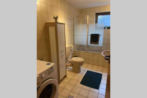 a bathroom with a washing machine and a toilet at Ferienwohnung Wille in Climbach