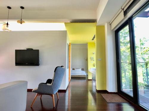 a living room with a chair and a television at Aqua Star Villa Homestay in Dongshan