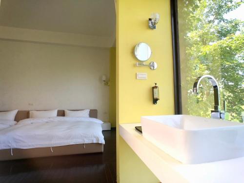 a bathroom with a white sink and a bed at Aqua Star Villa Homestay in Dongshan