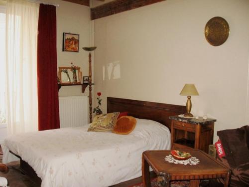 1 dormitorio con cama, mesa y sofá en Sylvie BARON - Composition Française - Chambres d'hôtes en Romans-sur-Isère