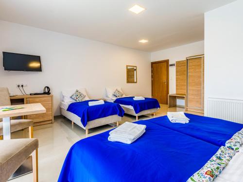 a hotel room with two beds and a tv at Źródło Raduni in Stężyca