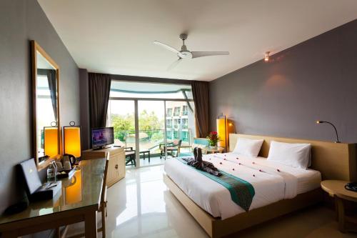 a bedroom with a bed and a desk and a television at Ramaburin Resort Patong - Walking distance to the Beach in Patong Beach