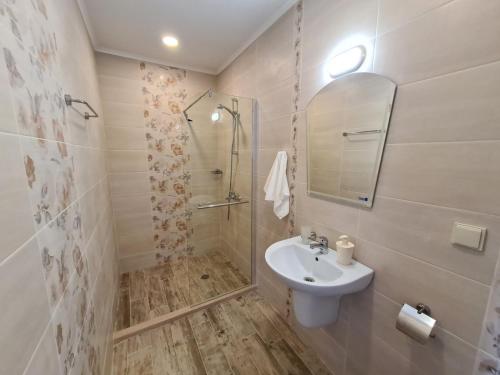 a white bathroom with a sink and a mirror at Villa Yanevi in Ravda