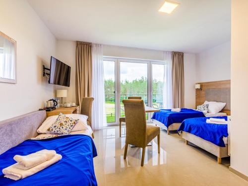 a hotel room with two beds and a table and chairs at Źródło Raduni in Stężyca