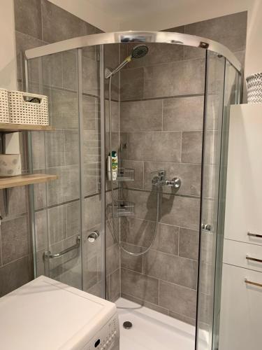 a shower with a glass door in a bathroom at Apartament Aria in Ełk