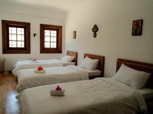 a hotel room with three beds with flowers on them at Guest Mansion, Гостински Палат in Rostuša