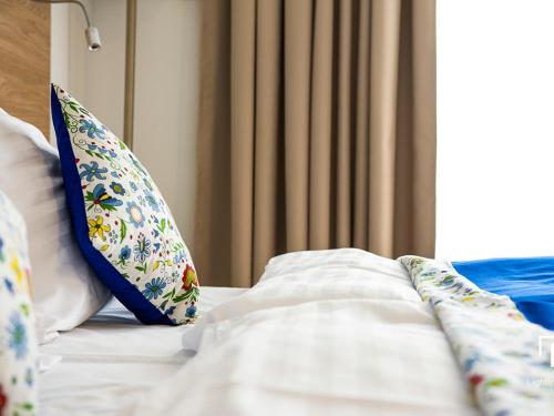 a bed with white sheets and pillows on it at Źródło Raduni in Stężyca