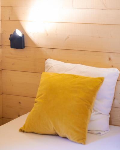 a yellow pillow sitting on top of a bed at Camping du Château Vert in Hondainville