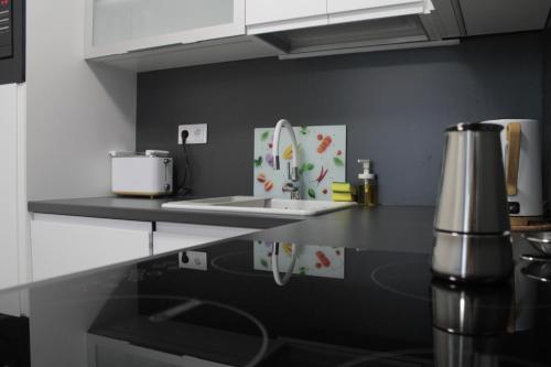 a kitchen with a sink and a counter top at Vízparti Apartman in Siófok