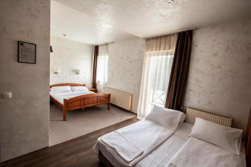 a hotel room with two beds and a window at Hotel Enigma in Žabljak