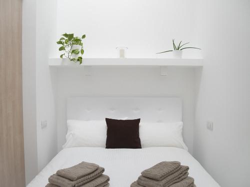 - une chambre blanche avec un lit et des serviettes dans l'établissement Brand new apartments Ortiquattro, à Milan