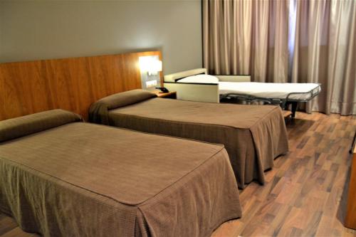 a hotel room with two beds and a bedvisor at Hotel AS Torrent in Torrent