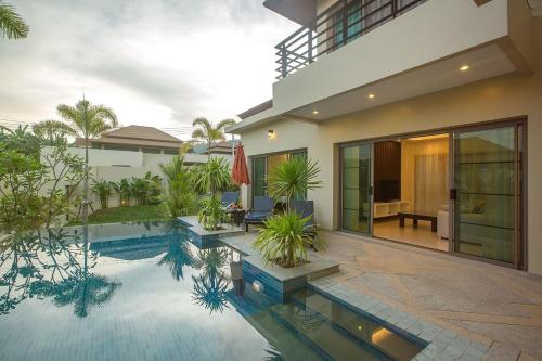 a house with a swimming pool in front of a house at Shanti Villas x MonthStayZ Thailand in Rawai Beach