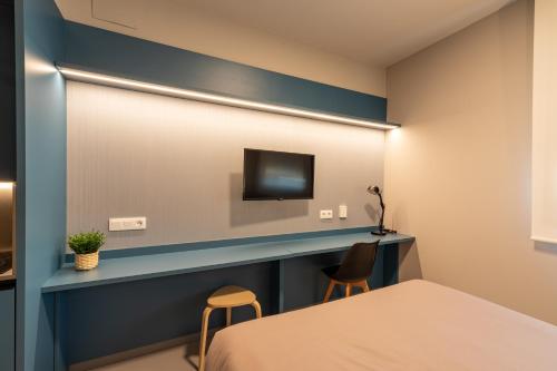 a hotel room with a bed and a television at Residencia Universitaria San Mamés in Bilbao