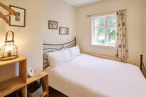 1 dormitorio con cama blanca y ventana en Host & Stay - Grange Cottage en Osmotherley