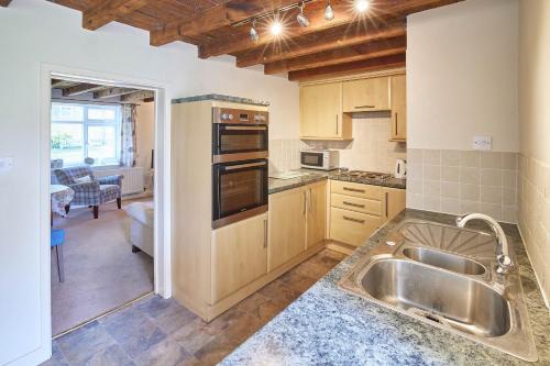 cocina con fregadero y fogones horno superior en Host & Stay - Grange Cottage en Osmotherley