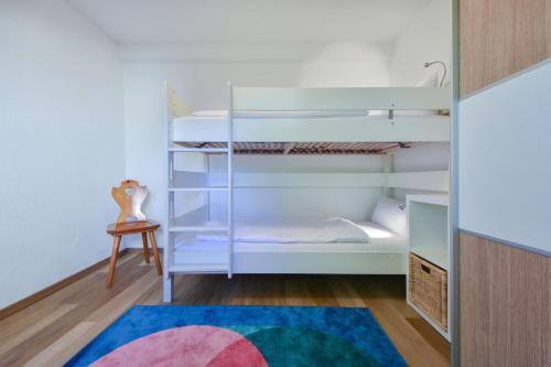 ein Schlafzimmer mit Etagenbetten mit Teppich in der Unterkunft Usedom To Hus in Ahlbeck