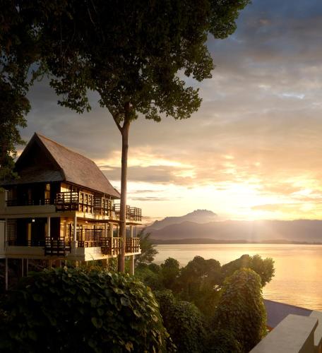 a building with a tree and a view of the water at Gaya Island Resort, Kota Kinabalu - a Small Luxury Hotels of the World in Gaya Island