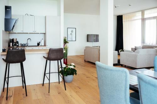 a kitchen and living room with chairs and a table at Intermar Hotel & Apartments in Glücksburg