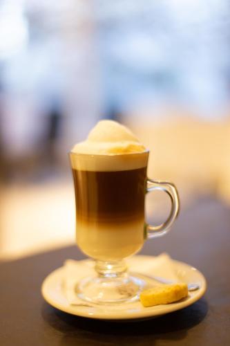 a cup of coffee on a plate with a cookie at Neuquén Tower Hotel in Neuquén
