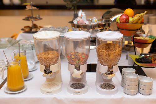 a table with four containers of food and orange juice at Neuquén Tower Hotel in Neuquén