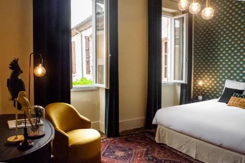 una camera da letto con un letto, una sedia e un tavolo di Les Chambres du Montréal et l'Hôtel particulier a Montréal