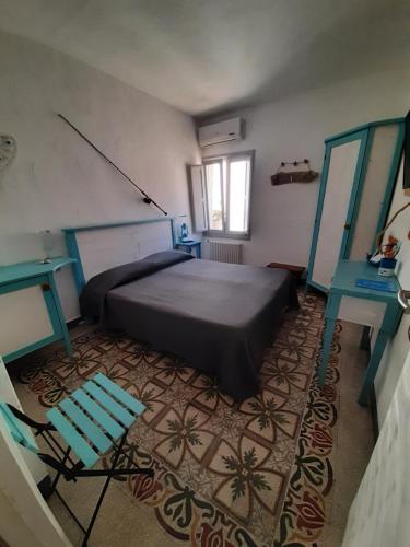 a bedroom with a bed and a blue chair at Casetta del Pescatore in Polignano a Mare