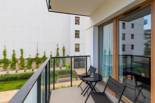 a balcony with a table and chairs on it at Nowa Letnica Apartments by Renters in Gdańsk