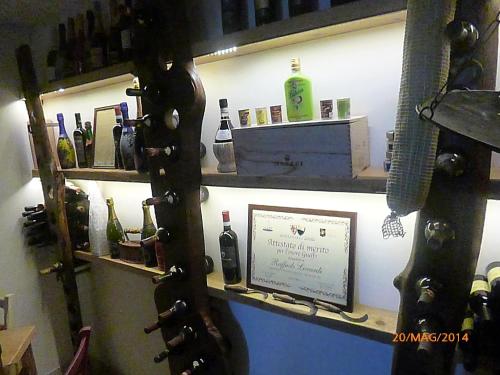 a room with a shelf with wine bottles on it at Albergo La Foresteria in Bettolle