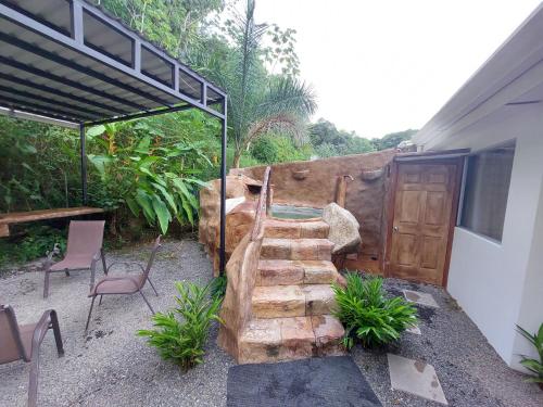 a garden with a wooden staircase next to a building at Villa privada con Jacuzzi Herradura Jaco in Herradura