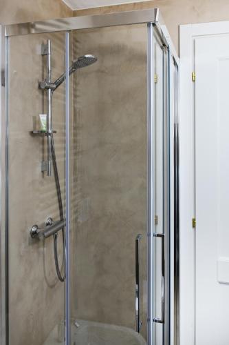 a shower with a glass door in a bathroom at Dimora Fortebraccio in LʼAquila