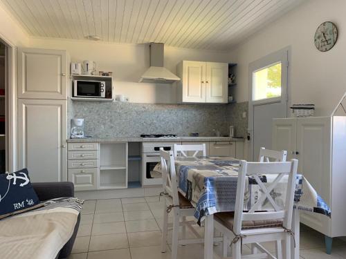 eine Küche mit einem Tisch und Stühlen im Zimmer in der Unterkunft les mouettes in LʼÎle-dʼOlonne