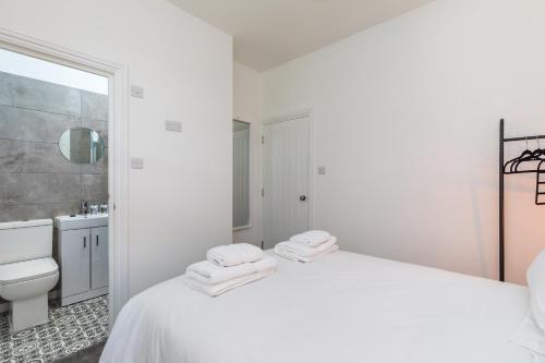 Un pat sau paturi într-o cameră la Hazelgrove Serviced Apartment by Huluki Sussex Stays